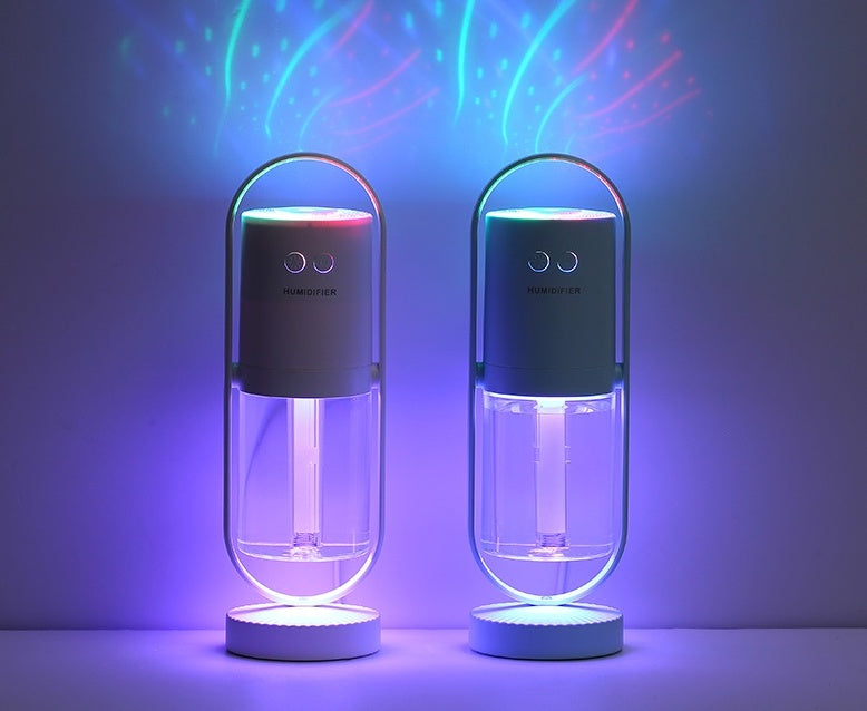 Two USB air humidifiers with projection night lights, one dark blue and one black, glowing with purple mist inside.