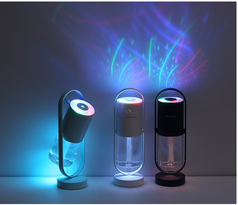 Three Magic Shadow USB air humidifiers in dark blue, white, and black with colorful projection night lights creating mist.