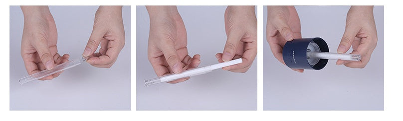 Cotton swab being held, dipped in liquid, and inserted into dark blue USB air humidifier opening.