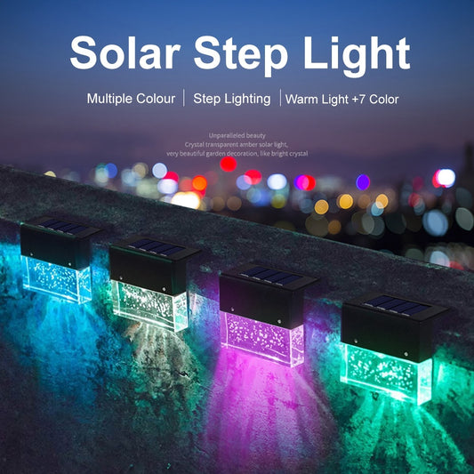 Row of black solar step lights emitting blue, purple, and green RGB LED glows on a wooden surface at night.