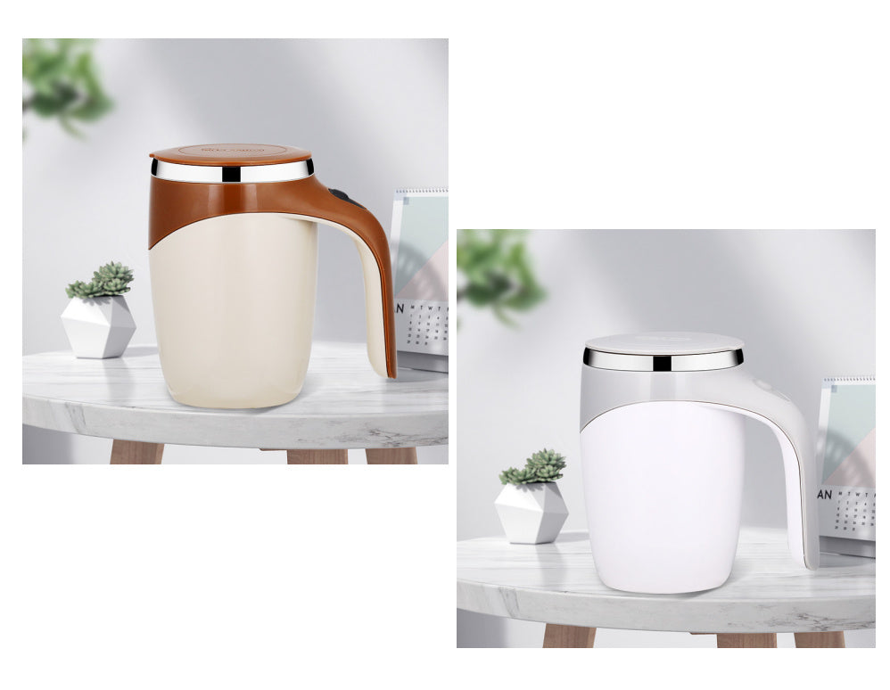 Set of two automatic stirring cups, one white and one beige with brown handle, both with silver lids on wooden surface.
