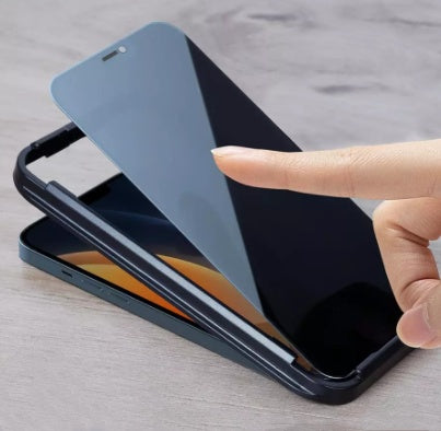 Black full screen privacy protection film being applied on a smartphone screen with a finger touching it.