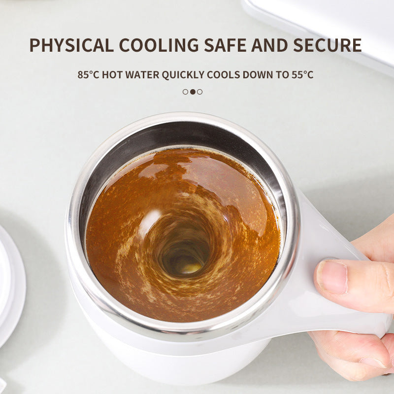 White electric automatic stirring cup with swirling coffee inside, stainless steel interior, held by hand.