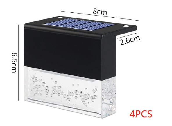 Compact black solar light with top solar panel and clear base filled with decorative bubbles, measuring 8cm by 6.5cm by 2.6cm.
